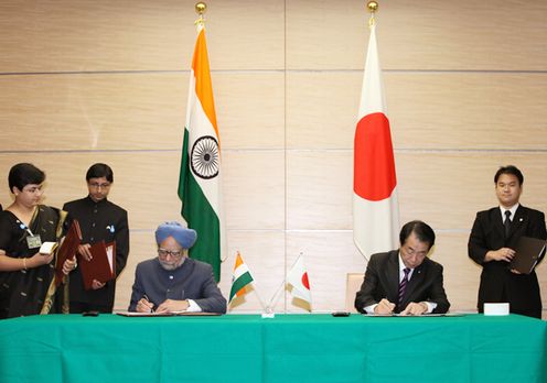 Photograph of the leaders signing a joint statement and other documents