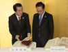 Photograph of Prime Minister Kan and President Lee Myung-bak of the Republic of Korea browsing through the books