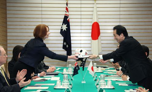 Photograph of Prime Minister Kan receiving a helmet from Prime Minister Gillard of Australia