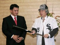 Photograph of Prime Minister receiving bunting tips wearing the uniform and cap given to him by Mr. Iguchi