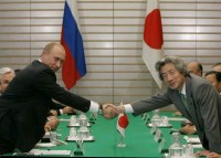 Photograph of Prime Minister Koizumi and President Putin shaking hands at the general meeting