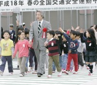 Photograph of Prime Minister participating with children in training for street crossing during a traffic safety lecture
