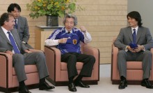 Photograph of Prime Minister Koizumi wearing the presented uniform and enjoying talks with Mr. Zico and Mr. Miyamoto