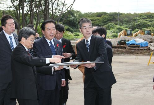 Photograph of the Prime Minister observing the planned construction site for a housing complex for public servants in Asaka 1