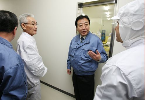 Photograph of the Prime Minister observing a fish processing facility