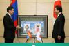 Photograph of Prime Minister Noda, following the signing ceremony, receiving an explanation on the display of the commemorative stamps produced in Mongolia