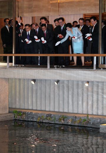 Photograph of the leaders feeding carps in the pond after the banquet held on the evening before the summit meeting