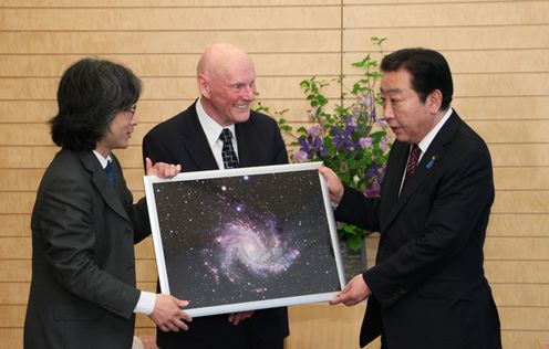 Photograph of the Prime Minister being presented with a picture panel of a spiral galaxy