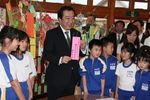 Photograph of the Prime Minister writing wishes on strips of paper for the star festival decoration with students at Kawauchi Elementary School