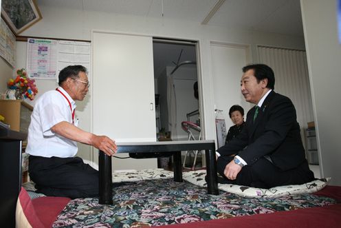 Photograph of the Prime Minister visiting the home of the head of the residents’ association in the temporary housing at Watanabemachihiruno