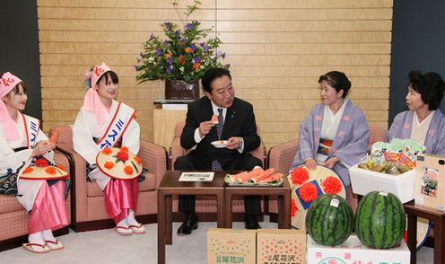 Photograph of the Prime Minister sampling the watermelons