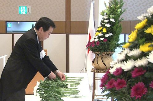 Photograph of the Prime Minister offering a flower at the Memorial Service
