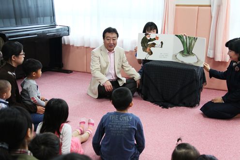 Photograph of the Prime Minister reading a picture book to children