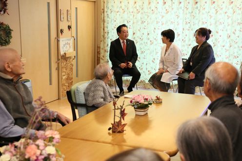 Photograph of the Prime Minister receiving an overview explanation when observing a group home 1